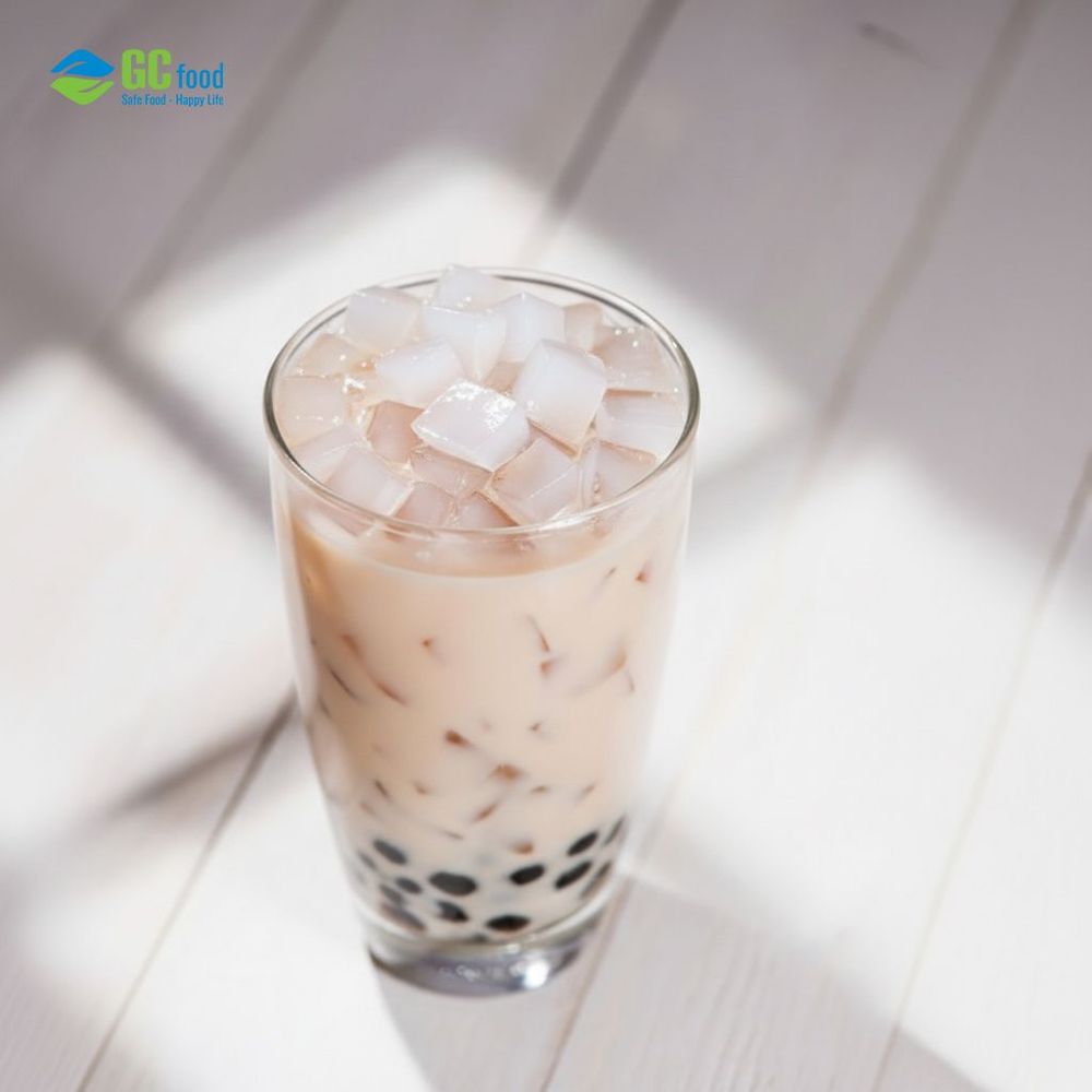 Almond milk tea served with coconut jelly topping offers a rich, creamy taste with a refreshing finish.
